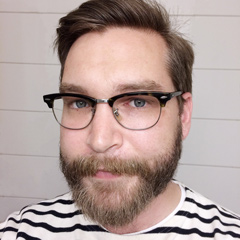 Emil Björklund, a guy with beard and glasses, in his thirties, wearing a striped sweater.